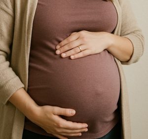 Pregnant woman torso holding stomach